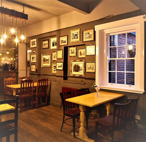 Dining room with framed photograph wall and sash window