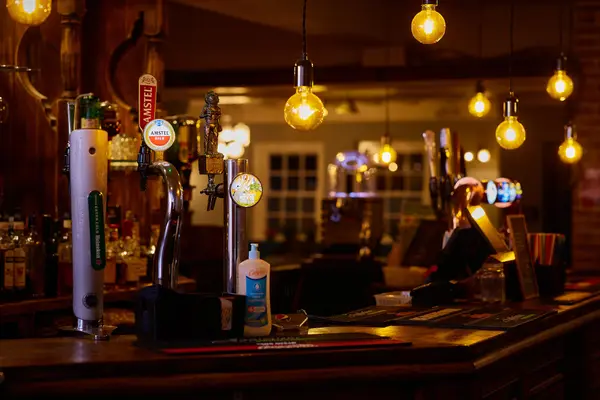 Draught beer taps under warm Edison bulb lighting