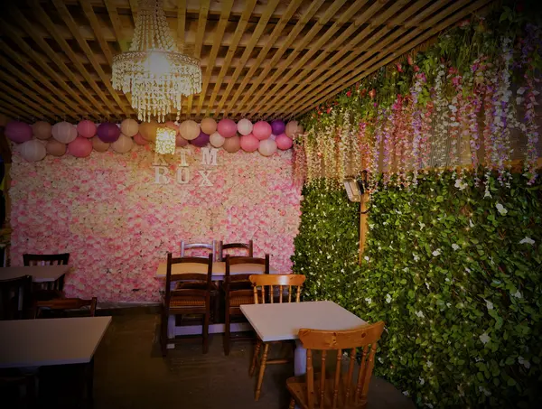 Private event space with a pink flower wall, balloons and chandelier