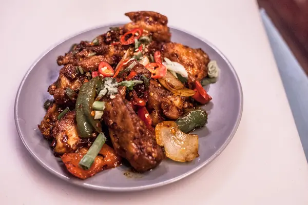 Chilli chicken tossed with peppers, onion and fresh chilli