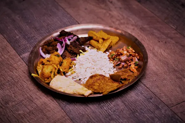 Nepalese platter with beaten rice, marinated meat, achar and soybeans