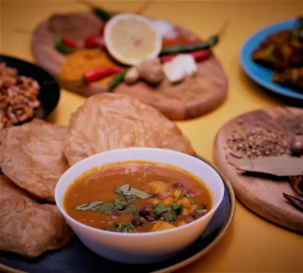 Chickpea curry served with puffed puri bread